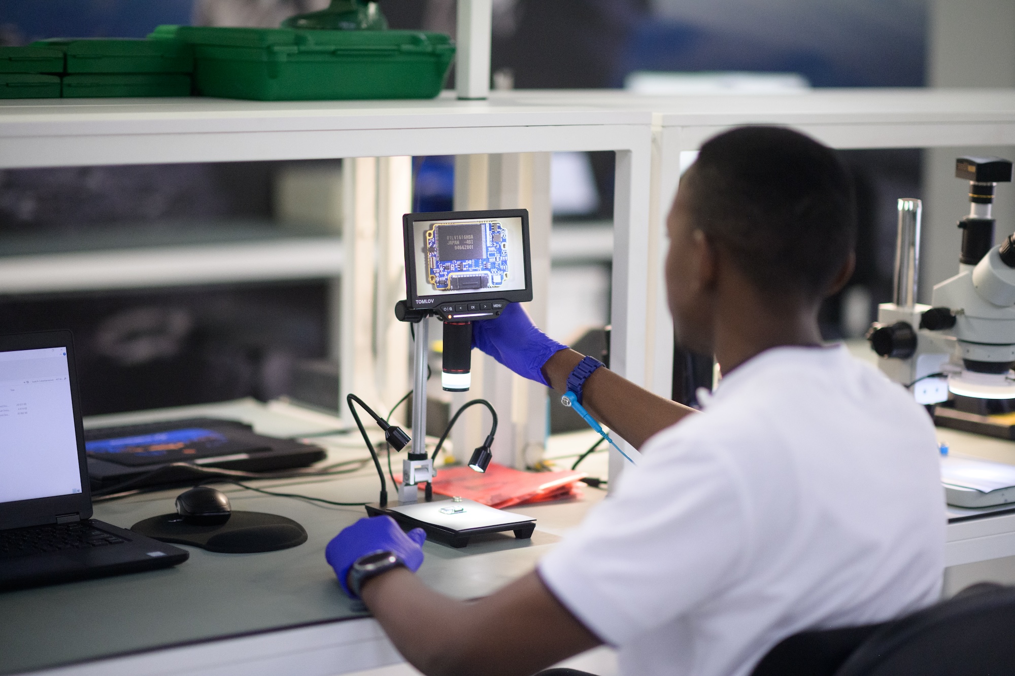 A CubeSpace engineer looking at a digital microscope display